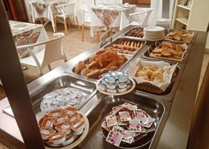 a buffet with several trays of food on a table at Hotel Mirage Spa in Carhué