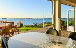 a table and chairs on a deck with a view of the water at 2 Bedroom Amazing Home In Faaborg in Faaborg
