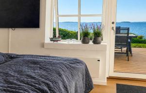a bedroom with a window with a view of the ocean at 2 Bedroom Amazing Home In Faaborg in Faaborg