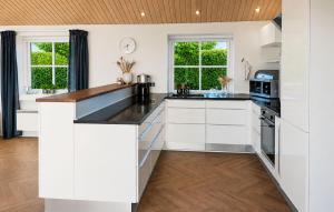 a kitchen with white cabinets and black countertops at 2 Bedroom Amazing Home In Faaborg in Faaborg +15 photos