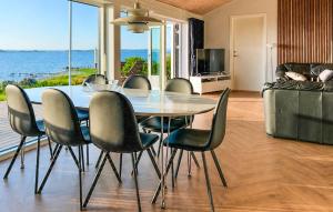 a dining room with a table and chairs and the ocean at 2 Bedroom Amazing Home In Faaborg in Faaborg