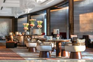 a dining room with tables and chairs and flowers at Shangri-La Nanjing in Nanjing