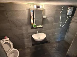 a bathroom with a toilet and a sink and a shower at D-Chu Mountain Haven Villas in Vang Vieng