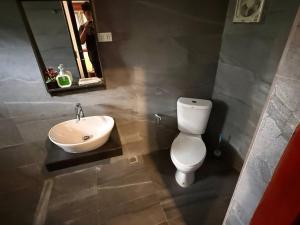 a bathroom with a white toilet and a sink at D-Chu Mountain Haven Villas in Vang Vieng