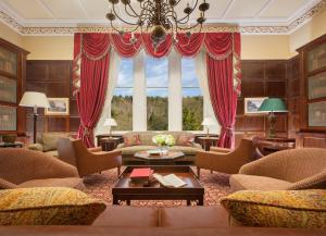 a living room with red curtains and a large window at Crossbasket Castle in High Blantyre