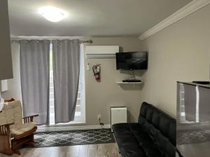 a living room with a couch and a tv at Wasaga Daze - Unit B in Wasaga Beach