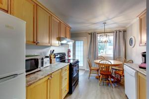 a kitchen with wooden cabinets and a table with chairs at Wasaga Daze - Unit A in Wasaga Beach