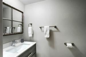 a bathroom with a sink and a mirror and towels at Wasaga Daze - Unit A in Wasaga Beach