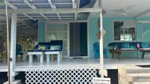 a porch with blue furniture on a house at LE FARE BLEU DUO 2 chambres climatisées avec 1 salle de bain - bord de lagon à Tiputa Rangiroa - vélos gratuits et snorkeling in Rangiroa