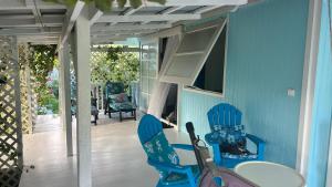 a room with blue walls and a table and chairs at LE FARE BLEU DUO 2 chambres climatisées avec 1 salle de bain - bord de lagon à Tiputa Rangiroa - vélos gratuits et snorkeling in Rangiroa