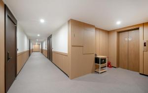 a hallway with wooden cabinets and a tv in it at MH Hotel 3 - Junghwasan in Jeonju