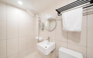 a white bathroom with a sink and a toilet at MH Hotel 3 - Junghwasan in Jeonju