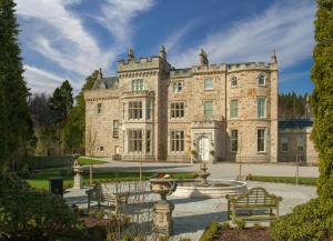 a large stone building with a fountain in front of it at Crossbasket Castle in High Blantyre