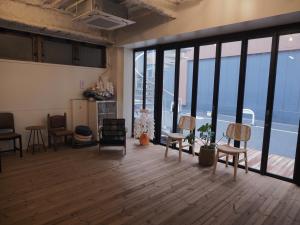 an empty room with chairs and tables and windows at Asagaya Iriguchi in Tokyo