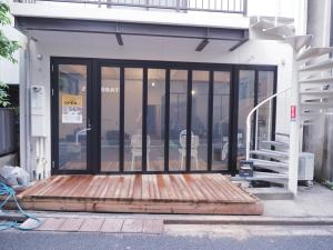 a store front with glass doors and a wooden platform at Asagaya Iriguchi in Tokyo