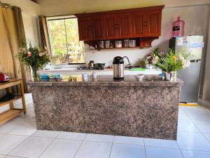 a kitchen with a granite counter top and a refrigerator at Tikary Lodge in Cusco