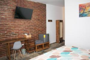 a bedroom with a brick wall and a tv on a wall at Ex Hacienda Santa Elena in Atlixco