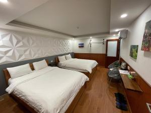 a room with two beds and a desk with a mirror at Flaco Hostel and Booking Office in Sapa