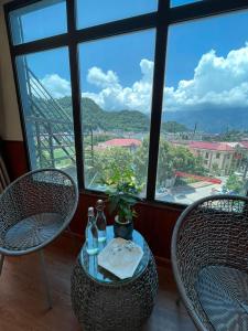 a table with two chairs and a table with two bottles at Flaco Hostel and Booking Office in Sapa