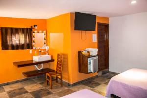 a room with orange walls and a sink and a bed at Ex Hacienda Santa Elena in Atlixco