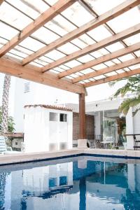 a swimming pool with a wooden pergola over it at Ex Hacienda Santa Elena in Atlixco