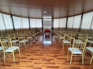 a room with rows of chairs and a red table at Tikary Lodge in Cusco