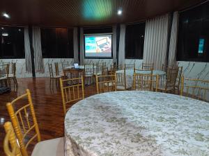a room with a large bed and chairs and a screen at Tikary Lodge in Cusco