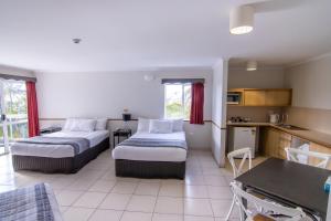 a hotel room with two beds and a kitchen at Ocean International Hotel in Mackay +26 photos