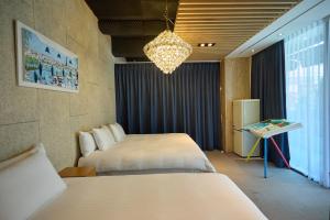 a hotel room with two beds and a chandelier at Acube Hotel Dongdaemun in Seoul +64 photos