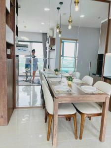 a dining room with a wooden table and white chairs at Livahome - PDT Lux homestay Di An HCMC in Dĩ An +26 photos