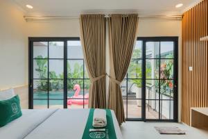 a bedroom with a bed and a large window at Sampai Villa Queensland in Pakem