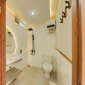 a white bathroom with a toilet and a sink at Sampai Villa Queensland in Pakem