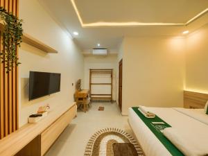 a hotel room with a bed and a flat screen tv at Sampai Villa Queensland in Pakem