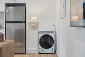 a washing machine in a kitchen next to a refrigerator at Ralph Escapes Yallingup in Yallingup