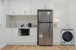 a stainless steel refrigerator in a kitchen with white cabinets at Ralph Escapes Yallingup in Yallingup