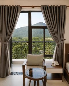 a living room with a large window with a view at Nam Hai Con Dao Hotel in Con Dao