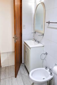 a bathroom with a sink and a toilet and a mirror at Departamento en el Centro de Mendoza, Parking Gratis, Check-in Autónomo in Mendoza