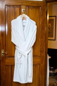 a white robe is hanging on a door at Koala Cottage in Ventnor