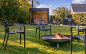 a group of chairs and a fire pit in a yard at Nice Home In Hadsund With Sauna in Hadsund