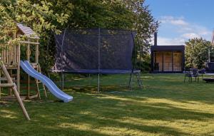 a playground with a slide in the grass at Nice Home In Hadsund With Sauna in Hadsund