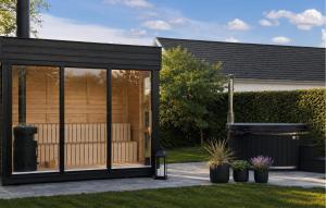 a black garden pavilion with plants in a yard at Nice Home In Hadsund With Sauna in Hadsund +22 photos