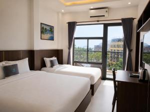 two beds in a hotel room with a window at Nam Hai Con Dao Hotel in Con Dao