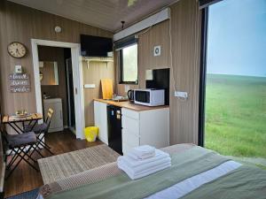 a room with a bed and a kitchen with a microwave at Bec's Place by Tiny Away in Fosterville