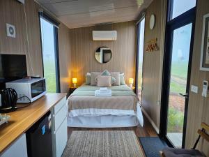 a bedroom with a bed and a tv and window at Bec's Place by Tiny Away in Fosterville