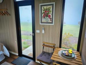 a room with a table and a door with a window at Bec's Place by Tiny Away in Fosterville +3 photos