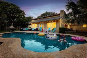 a swimming pool with inflatables in front of a house at 6BR Pool & Game Arcade Family Dog Friendly in San Antonio