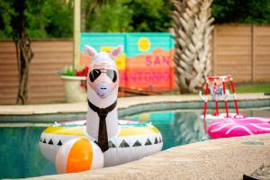 a toy cow on an inflatable raft in a pool at 6BR Pool & Game Arcade Family Dog Friendly in San Antonio