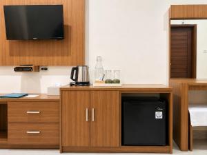 a kitchen with a desk with a microwave and a television at Eslem GuestHouse in Canggu