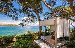 a treehouse with a bench in front of the water at Villa Ana in Jelsa +29 photos