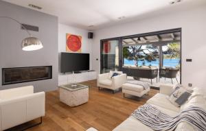a living room with white furniture and a flat screen tv at Villa Ana in Jelsa